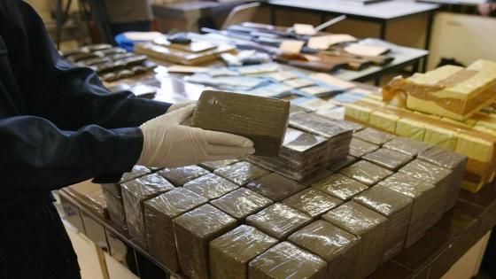 des enquêteurs de la section de recherches de la gendarmerie de Bordeaux présentent des paquets contenant du cannabis, le 21 novembre 2003, à l'issue d'une opération qui a permis la saisie de 150 kg de cannabis, 80 000 euros en liquide, huit fusils à pompe, 9 véhicules de grosse cylindrée et plus de 260 000 euros de valeurs en bijoux et autres objets mobiliers. Seize personnes de nationalité française ont été interpellées dans le cadre du démantèlement d'un "très important réseau" de trafic de drogue entre la France et l'Espagne, a-t-on appris auprès de la gendarmerie. An investigator shows packs of cannabis displayed at Bordeaux' police station 21 November 2003. 150kg of cannabis, 80 000 euros in cash, 8 pump action shot guns, more than 260 000 euros worth of jewelry and 9 cars were seized following an operation to dismantle a drug trafficking network between France and Spain.