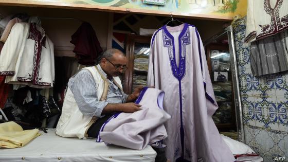 A picture taken on May 21, 2018, shows Habib stitching a Jebba (a traditional dress) at a store in the capital Tunis. (Photo by FETHI BELAID / AFP)