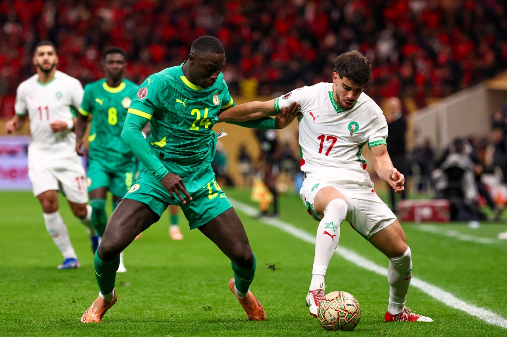 Morocco's midfielder #17 Abde Ezzalzouli fights for the ball with Senegal's defender #24 Antoine Mendy during the Africa Cup of Nations (CAN) final football match between Senegal and Morocco at the Prince Moulay Abdellah Stadium in Rabat on January 18, 2026. (Photo by FRANCK FIFE / AFP)